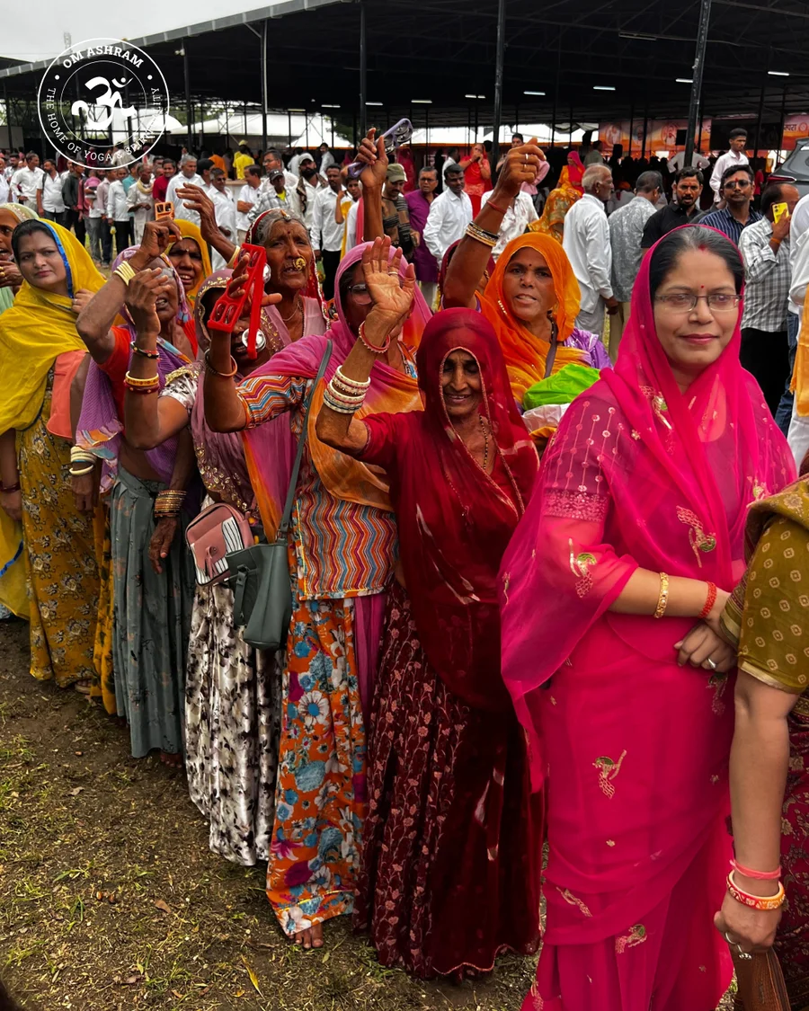 A long line of people in colorful clothing waiting for a blessing.